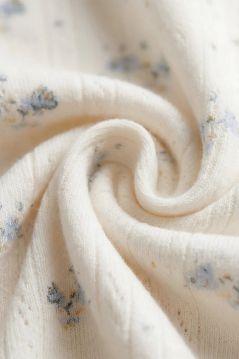 Close-up of soft fabric with small blue floral patterns on a light background