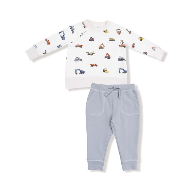Children's outfit with long-sleeve shirt with construction vehicle print on it and pants on a white background