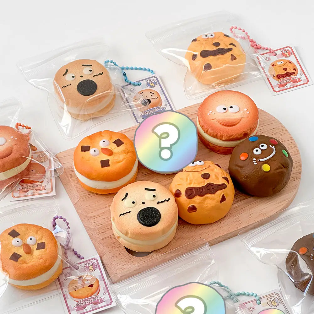 Animated donuts with various expressions on keychains wooden board with packaging in the background.