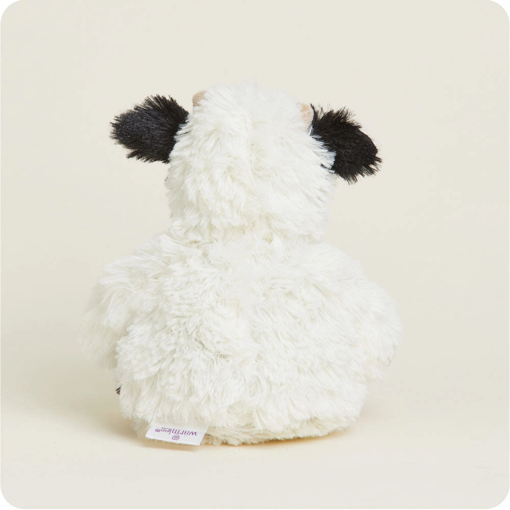 White plush toy with black accents on a beige background