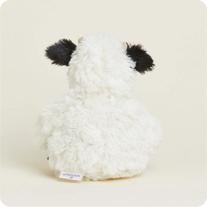 White plush toy with black accents on a beige background