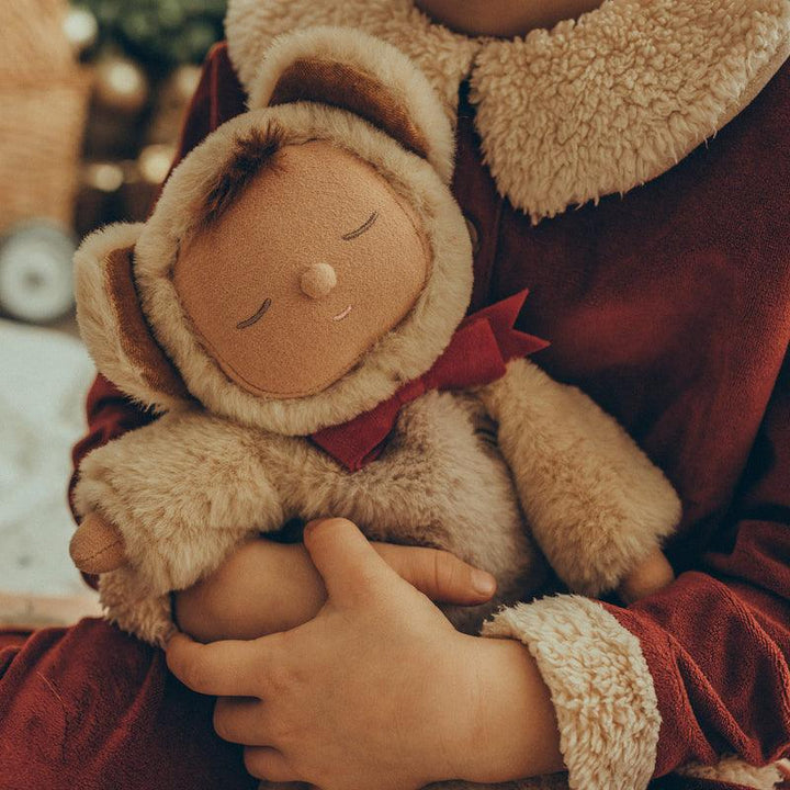 baby doll dressed as a teddy bear being snuggled by a child