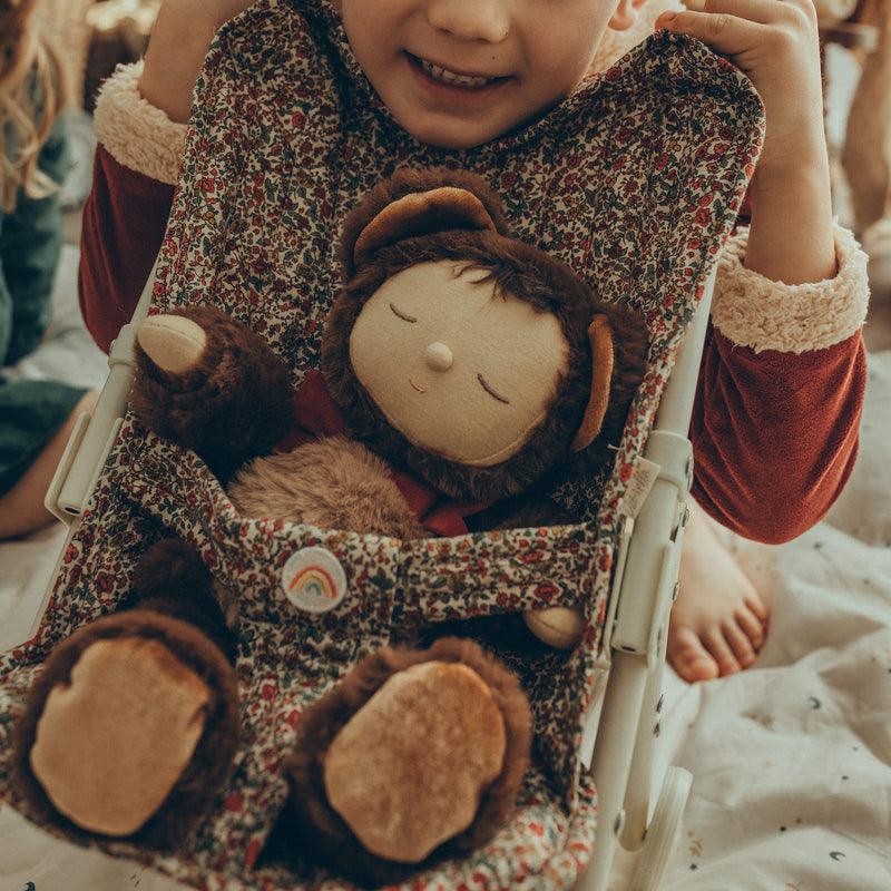 baby doll dressed as a teddy bear in a stroller with young kid pushing stroller