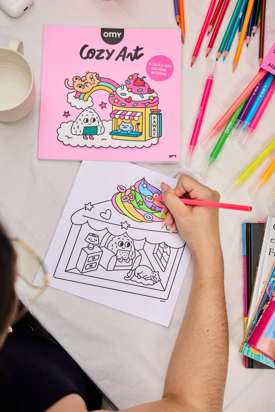 someone coloring in a coloring book titled cozy art using markers