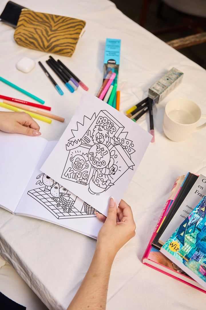 inside pages of a cozy art coloring book and some markers