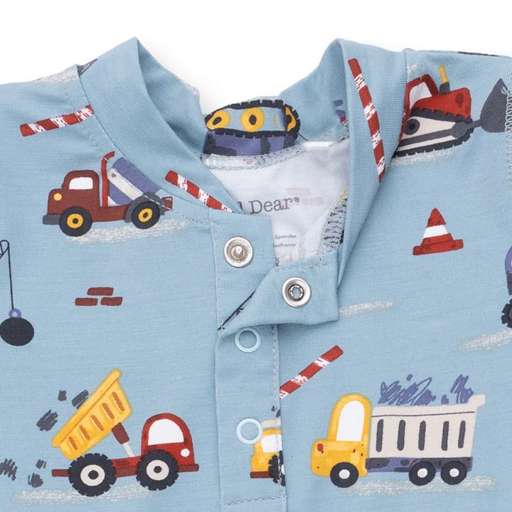 Children's shirt with construction vehicle pattern on a light blue background