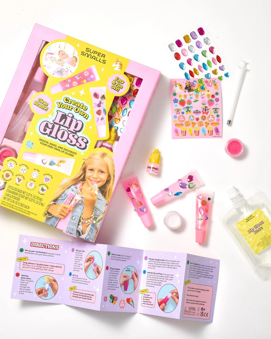 Children's nail polish kit with colorful bottles, a book, and accessories on a white background