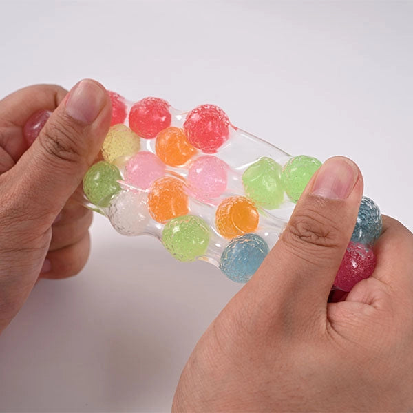 two hands showing the squihs toy and how it stretches. 