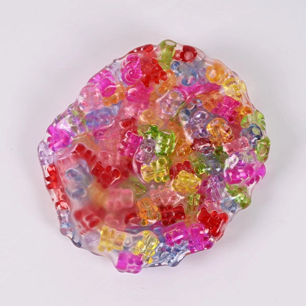 Colorful gummy bear candies in a clear plastic mold on a white background