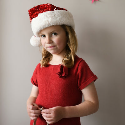 little girl modeling the velvet sequin santa hat.