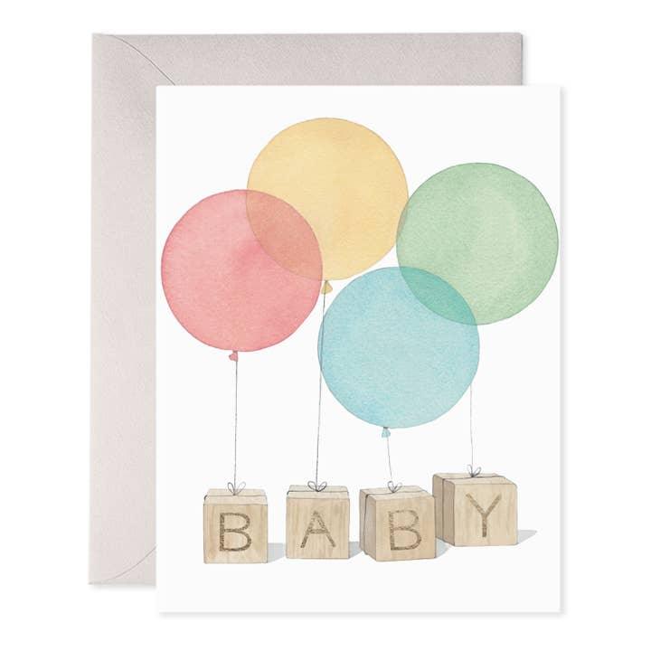 greeting card for a new baby. baby blocks spell out 'BABY' with all different color balloons tied to the blocks. 