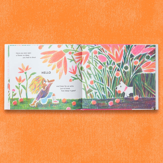 Colorful children's book open to a page with illustrations of a fairy and a dog in a garden on an orange background.