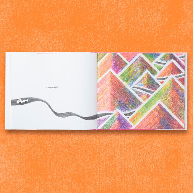 Open book with colorful geometric pattern and road illustration on an orange background