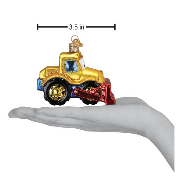 Decorative toy bulldozer ornament held in a hand with measurement label