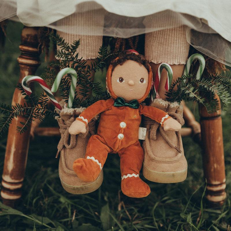 baby doll dressed as a gingerbread cookie with green bow tie