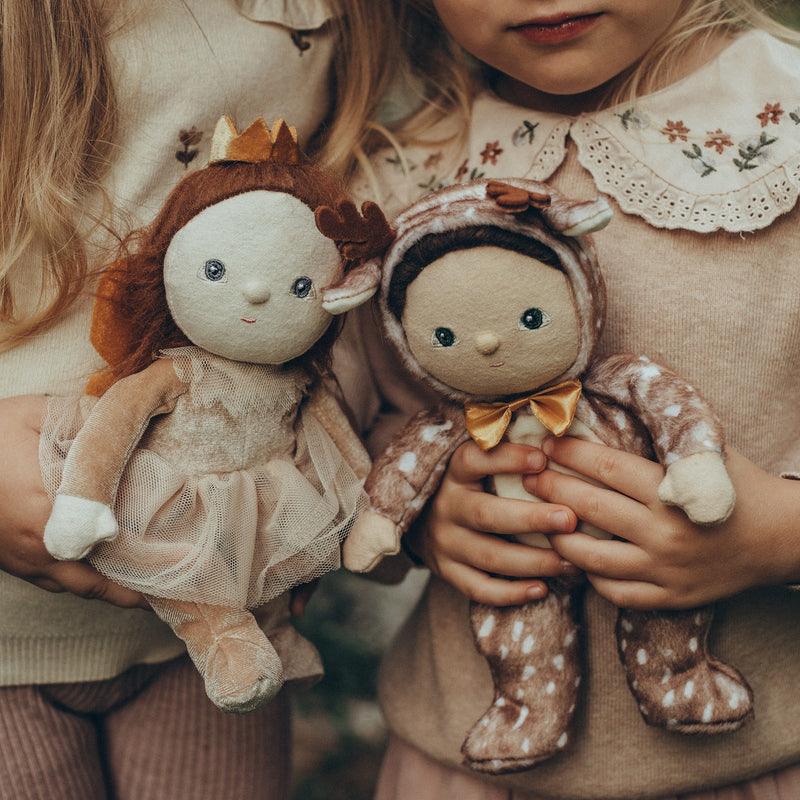 two children cuddling the babydolls, one reindeer and one sugarplum fairy