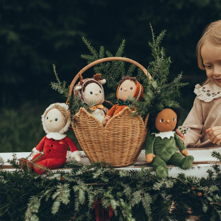 holiday dinkum babies all lined up near christmas evergreen in a basket