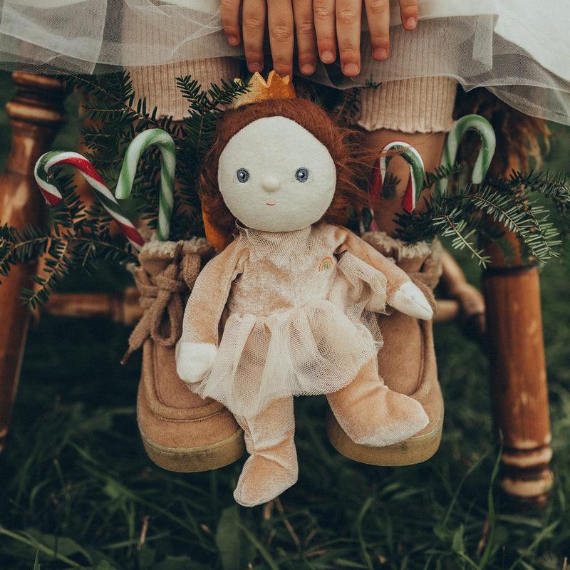 baby doll dressed as a sugar plum fairy sitting in the grass