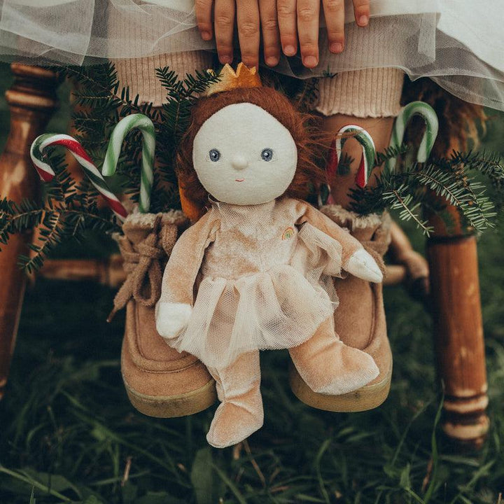 baby doll dressed as a sugar plum fairy sitting in the grass