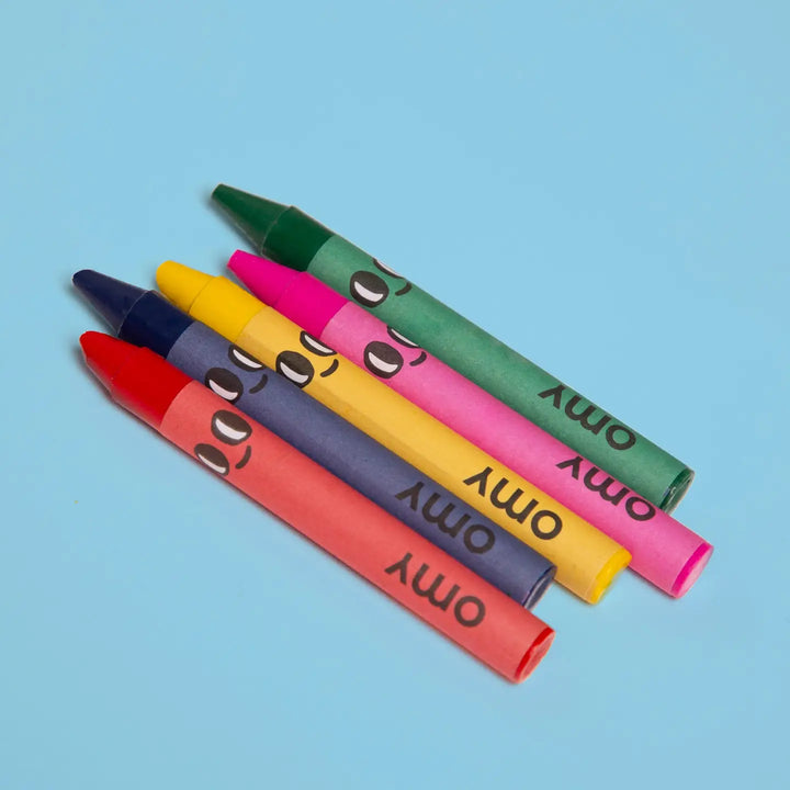 close up of crayons. the papers of the crayons have eyes and a smiley face on them. 