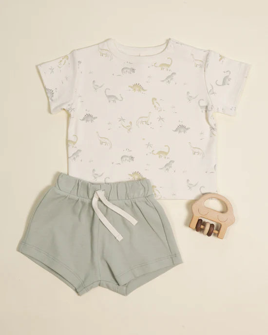 Children's outfit with t-shirt and shorts, accompanied by a wooden teething ring on a beige background
