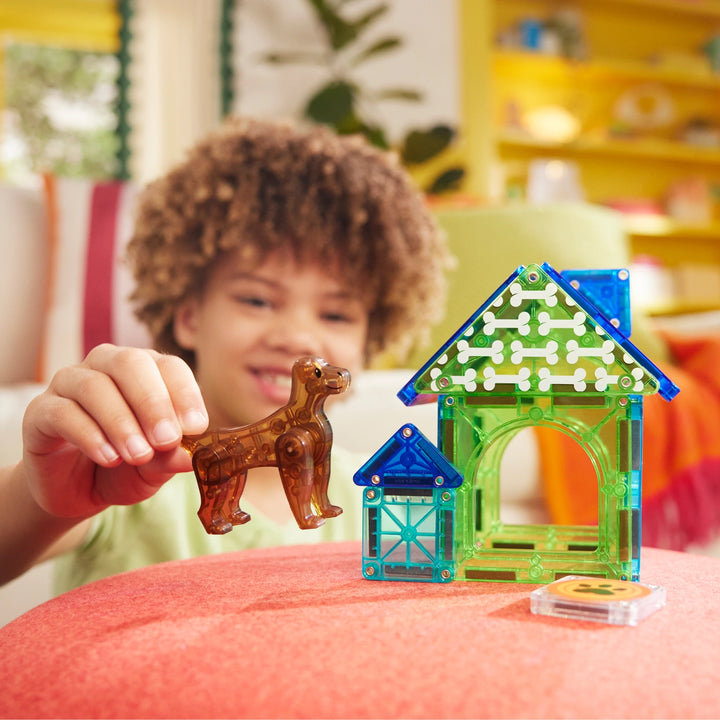 Child playing with a transparent pet house and dog figure on a colorful surface.
