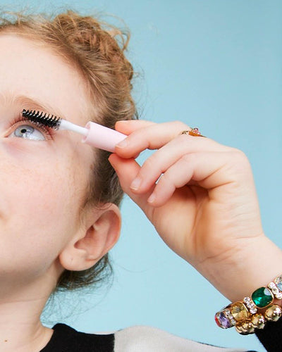 picture of a girl putting on mascara 