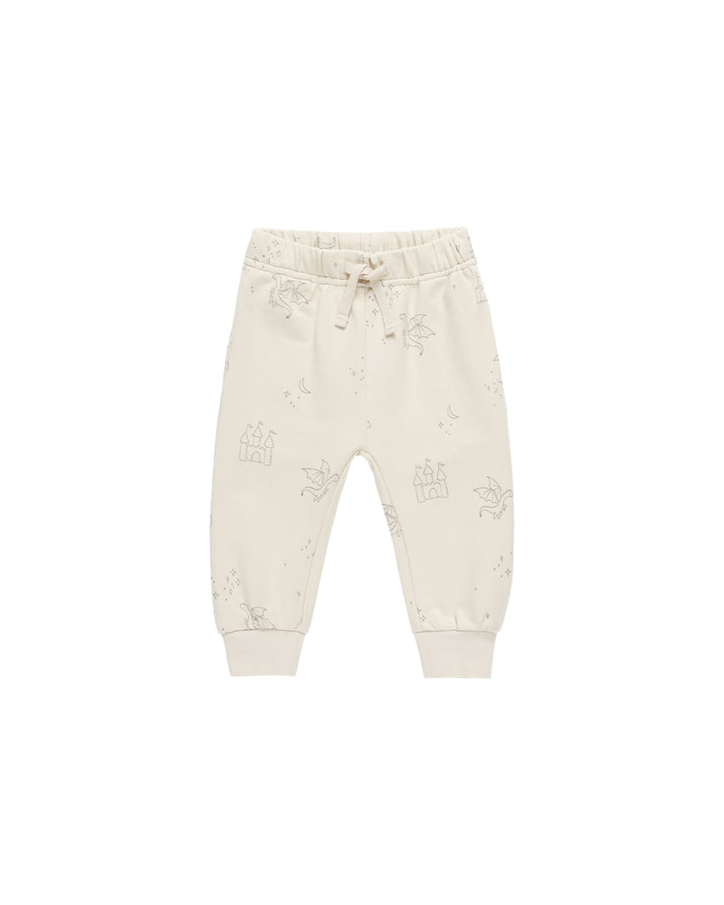 beige sweatpants with drawstring with age green dragons and castles printed all over. 