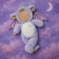 Plush toy dragon lying on a purple cloud with a moon in the background