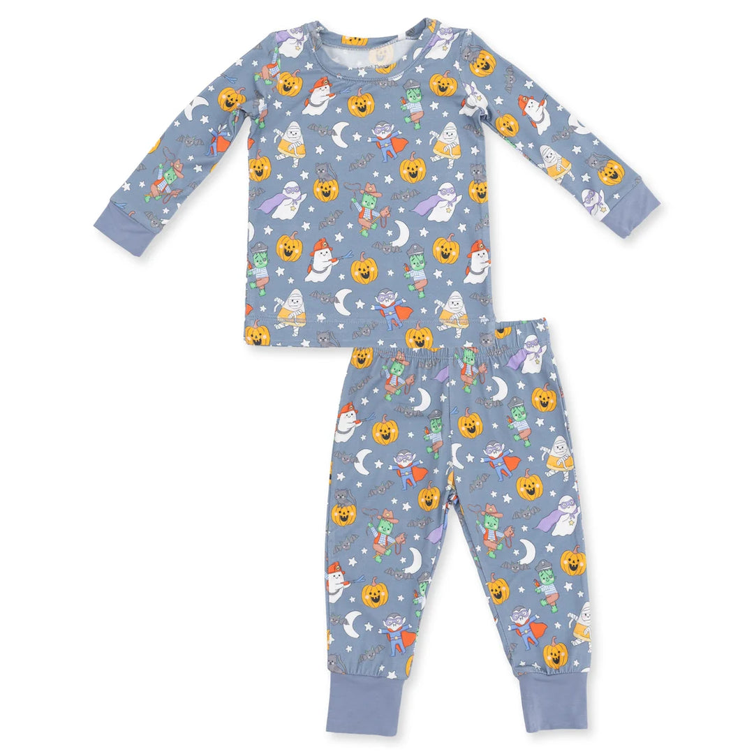 A two-piece children's pajama set featuring a long-sleeve top and matching pants in a dusty blue color, both covered in a playful Halloween-themed print of jack-o'-lanterns, ghosts, moons, stars, and candy corn.