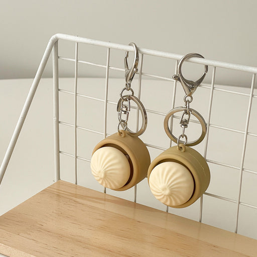 Two round keychains with a beige dumpling attached 