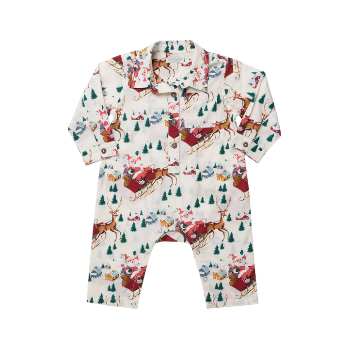 A baby long-sleeve romper with a holiday Christmas print featuring Santa Claus in red sledding, brown reindeer, green pine trees, and snowy houses on an off-white background.
