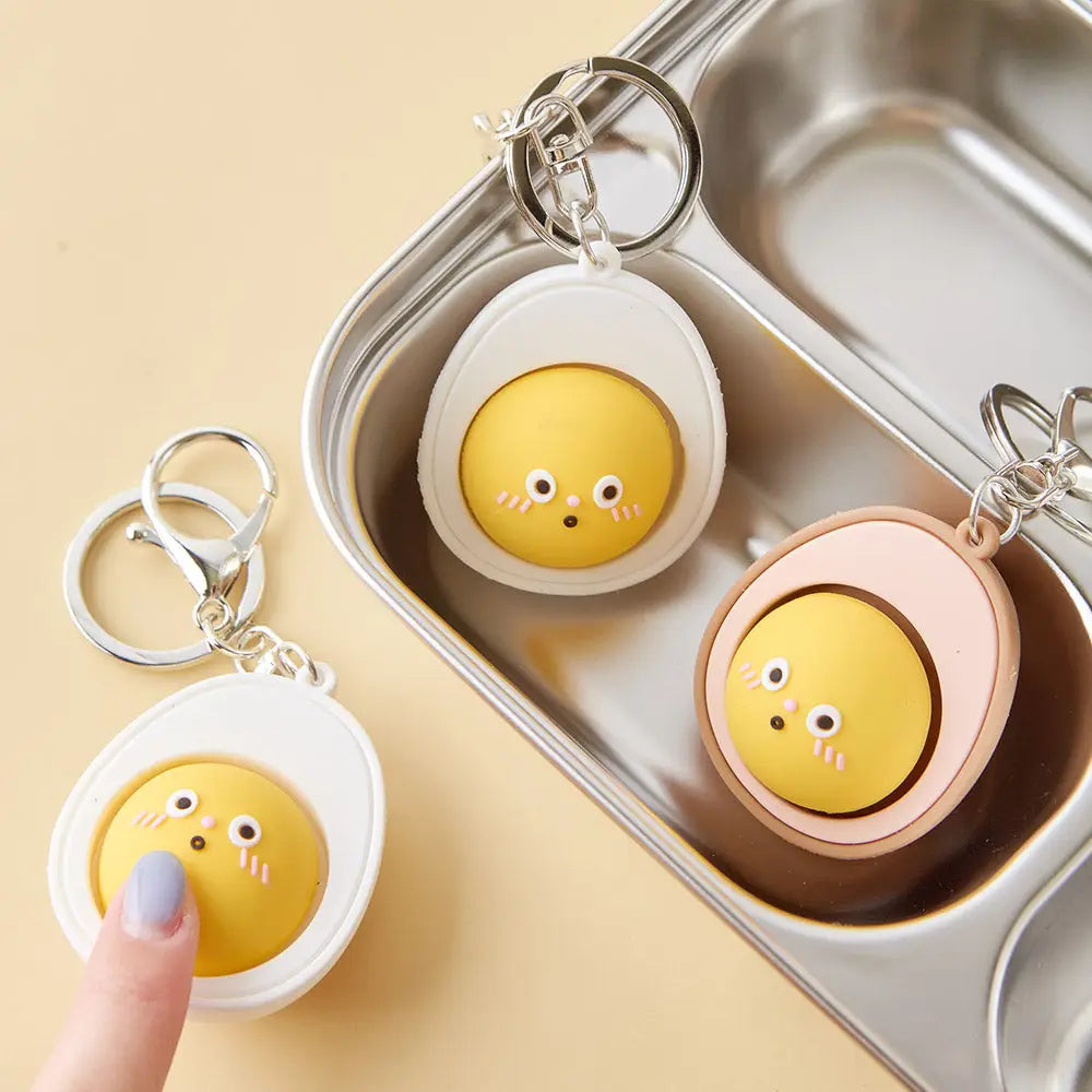 egg yolk keychain that comes in both colors: white and brown with a face on the yolk. 