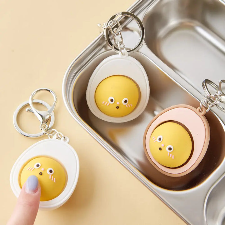 egg yolk keychain that comes in both colors: white and brown with a face on the yolk. 