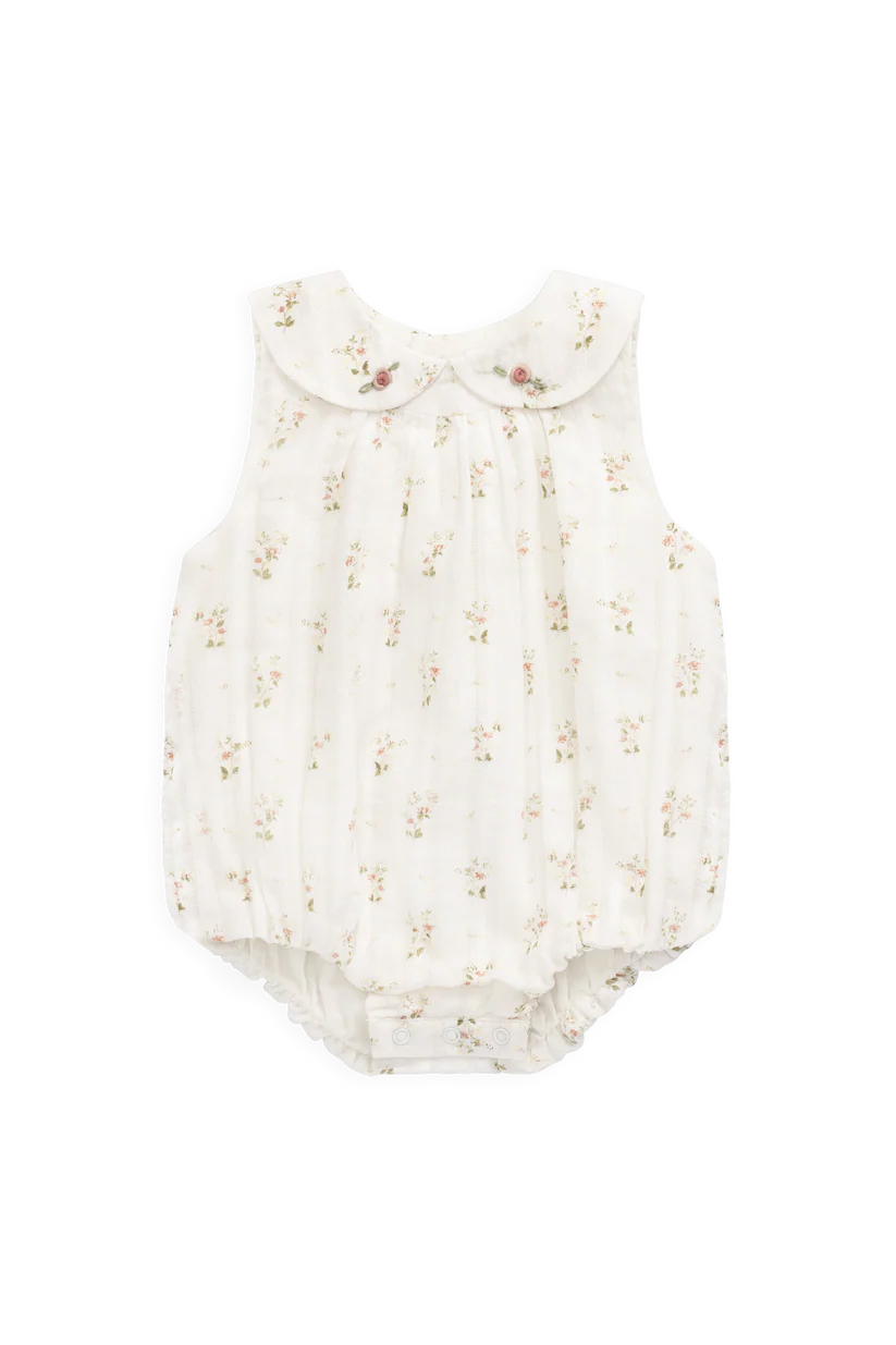 White baby romper with floral pattern on a white background
