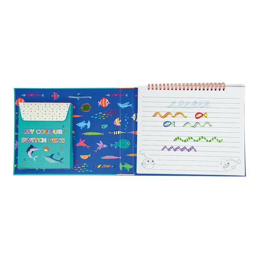 this picture shows inside of color magic book with lined pages on one side and color switch magic markers on the other side. 