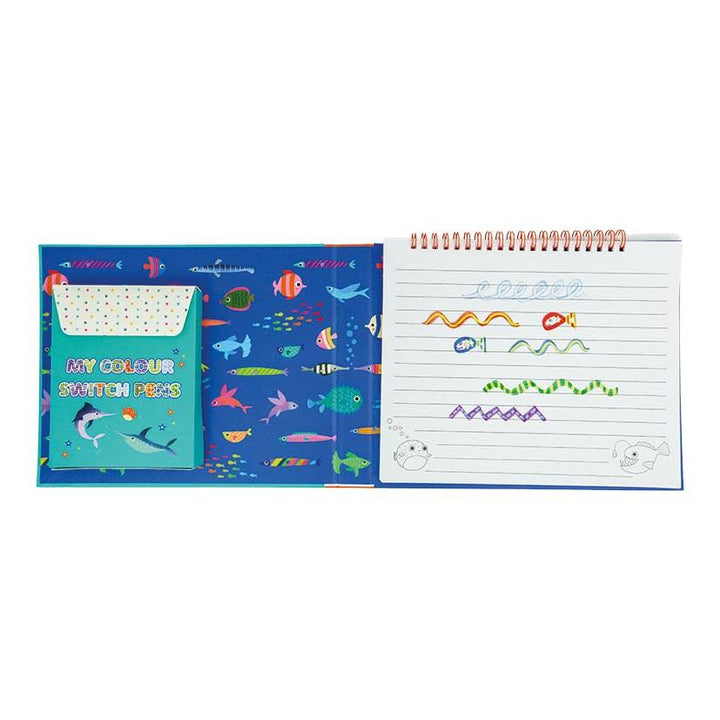 this picture shows inside of color magic book with lined pages on one side and color switch magic markers on the other side. 