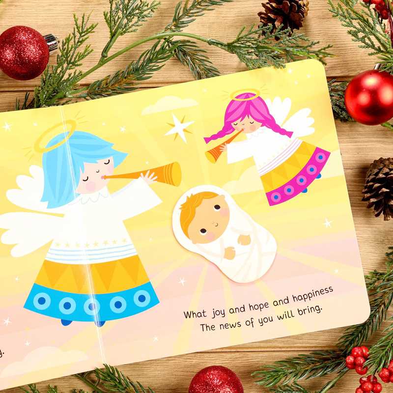 Children's book with Christmas-themed illustrations on a wooden surface with festive decorations.