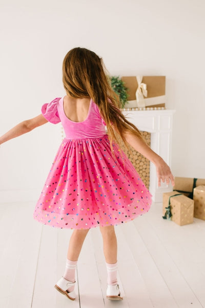 the little girl is modeling this bubblegum pink velvet dress and this picture shows the dress from the back and how it has a scoop back. 