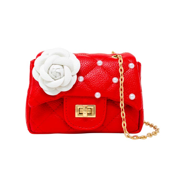 red quilted handbag with pearl studs and white flower on the side of the front flap. gold chain link for shoulder strap