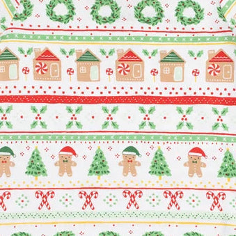 A long-sleeve children's holiday sweater with a festive Christmas fairytale pattern featuring gingerbread houses, elves, snow globes, wreaths, and snowmen in red, green, and brown on a white background.