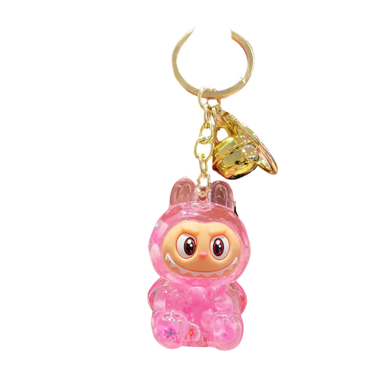 labubu inspired keychain in clear charachter filled with pink glitter and confetti attached to a gold ring.