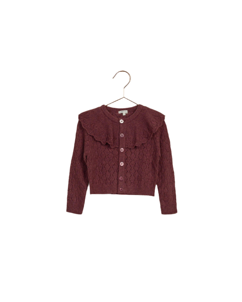 girls cardigan that is a burgundy wine color, it appears fuzzy and soft. large ruffle around the collar and buttons down the center. 