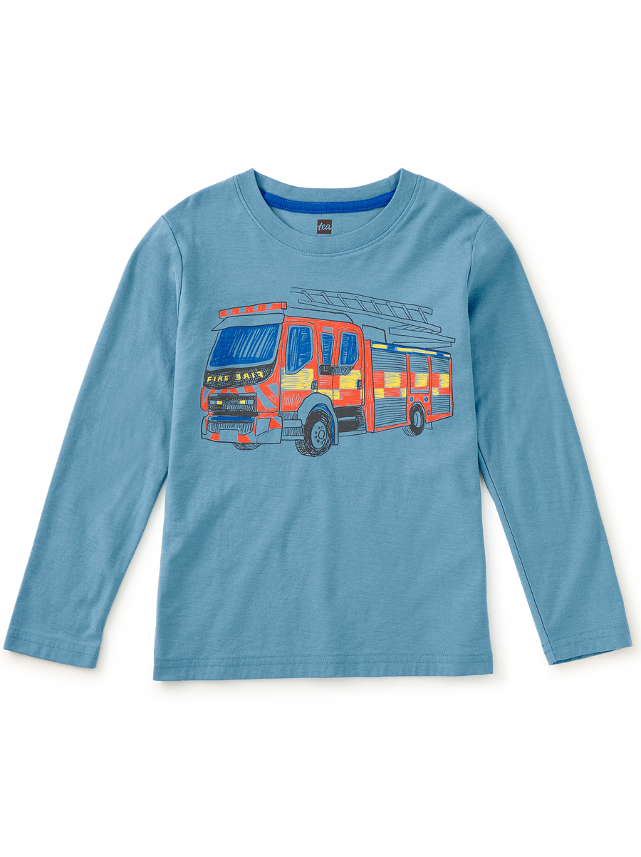 A light blue long-sleeve children's t-shirt featuring a colorful graphic of a fire engine on the front chest, displayed against a solid white background.