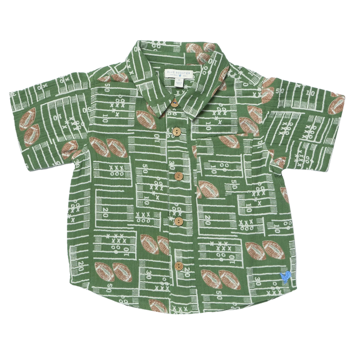 A short-sleeve button-up shirt for kids, featuring an all-over football field and football pattern in green, white, and brown, laid flat against a white background.