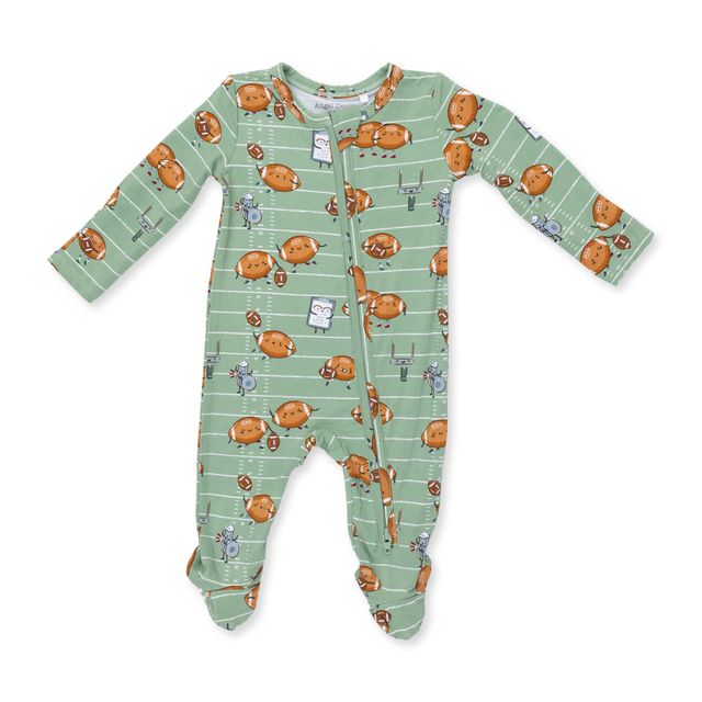 baby footie with footballs playing football. green background with white prinstripes going across it. 