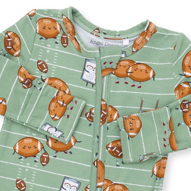 close up on the top of the baby footie with footballs playing football. green background with white stripes as the background. 