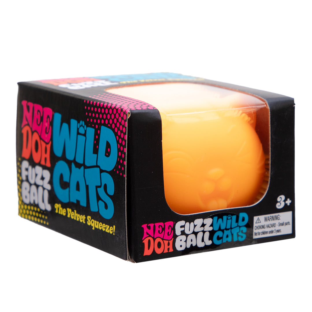 A boxed orange-yellow plush squeeze ball toy labeled 'Nee Doh Wild Cats Fuzz Ball' in black retail packaging with colorful text and a clear window showing the ball inside.