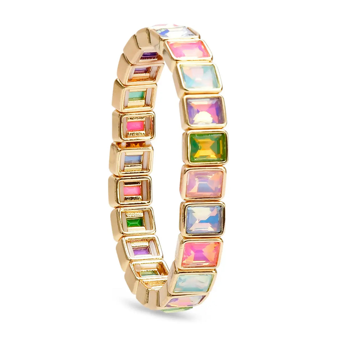 A gold-plated bangle bracelet featuring multiple square-cut iridescent gemstones in pink, green, blue, and purple, set against a plain white background.