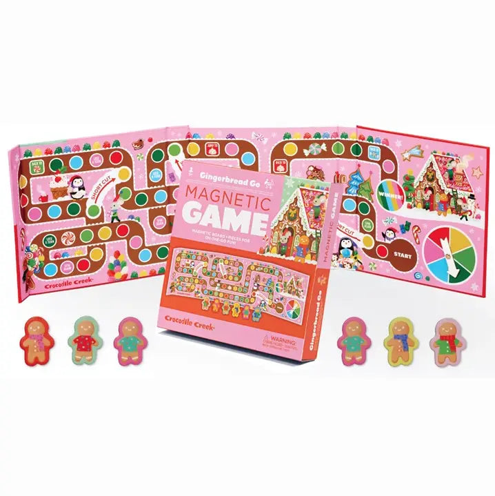 Gingerbread Gang Magnetic Game set with a pink board game box in the center and three matching game boards fanned behind it on a white background. Small gingerbread person tokens are lined up in front of the box.